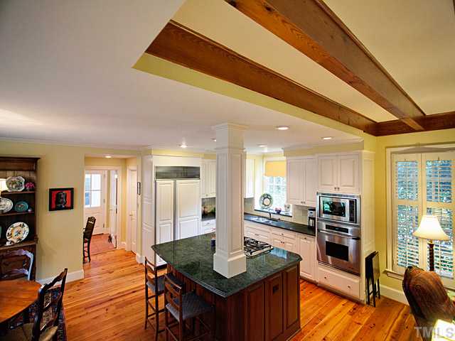 1908 Chase Court Raleigh, NC 27607 - Photo 8 of 25 a kitchen with stainless steel appliances kitchen island granite countertop a table chairs in it and wooden floors