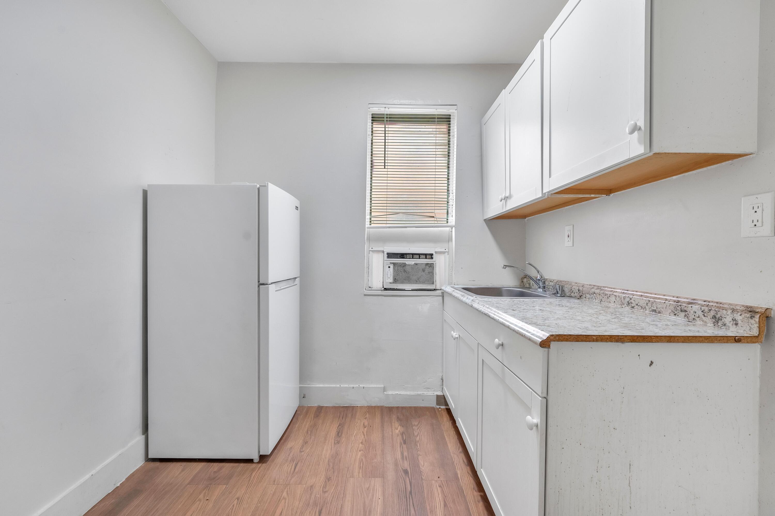1554 Southwest 5th Street, Unit 3A Miami, FL 33135 - Photo 5 of 13 a kitchen with a sink a refrigerator a stove and white cabinets