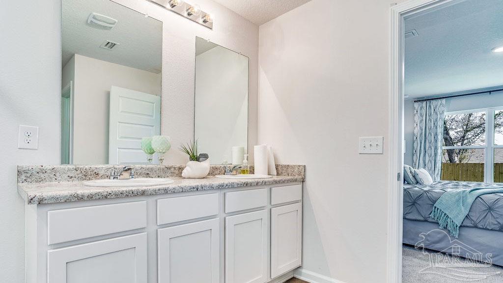 5084 Rainwater Road Milton, FL 32583 - Photo 18 of 26 a en suite bathroom with a granite countertop sink and a mirror