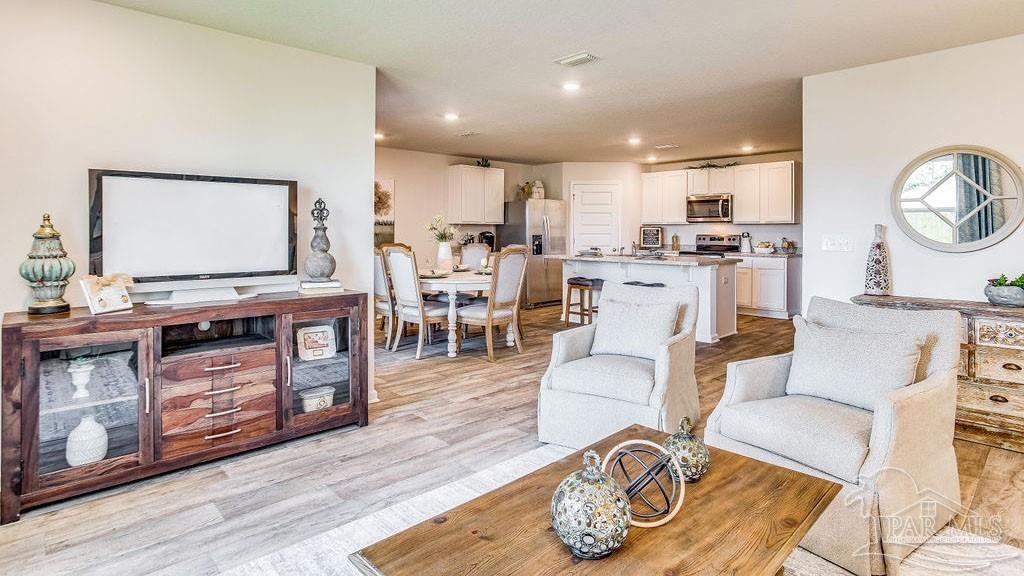 5084 Rainwater Road Milton, FL 32583 - Photo 9 of 26 a living room with furniture a flat screen tv and kitchen view