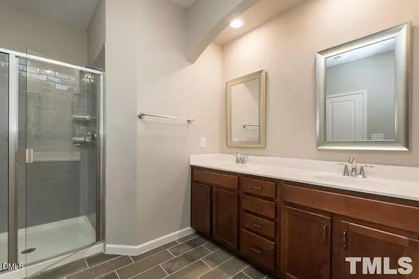 a bathroom with a double vanity sink mirror and shower
