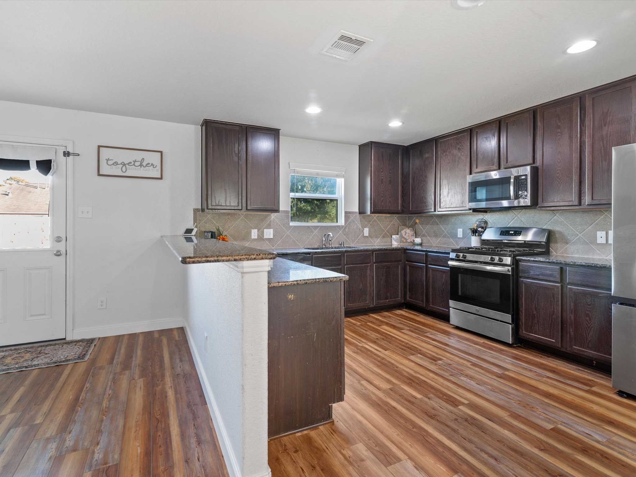 2535 Zephyr Lane Rosenberg, TX 77471 - Photo 21 of 40 a kitchen with wooden floors and wooden cabinets