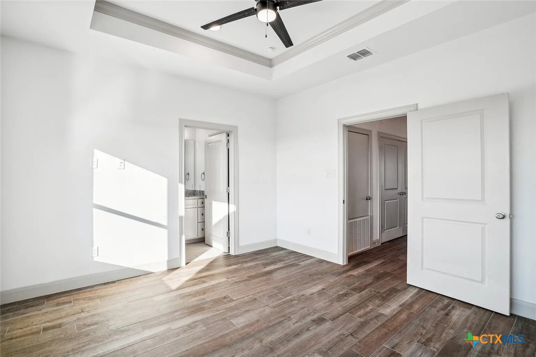 289 Star Grass, Unit 3 Spring Branch, TX 78070 - Photo 29 of 40 a view of a room with wooden floor and a ceiling fan