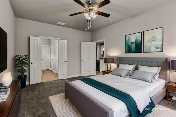 a bedroom with a large bed and a chandelier