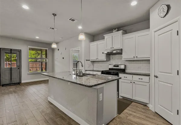 a kitchen with stainless steel appliances granite countertop a sink stove and cabinets