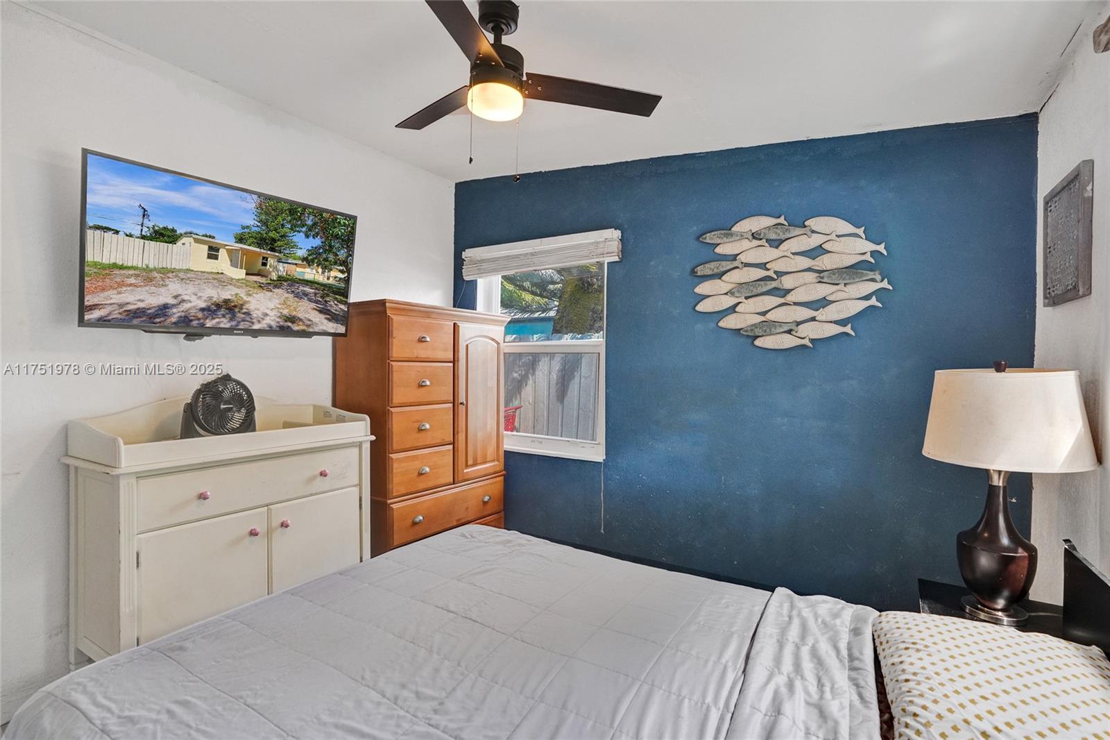 2091 Rutland Street Opa-Locka, FL 33054 - Photo 12 of 25 a bedroom with a bed and a lamp on dresser