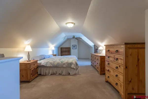 a spacious bedroom with a bed and a lamp