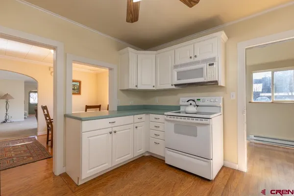 a kitchen with stainless steel appliances granite countertop a stove and white cabinets
