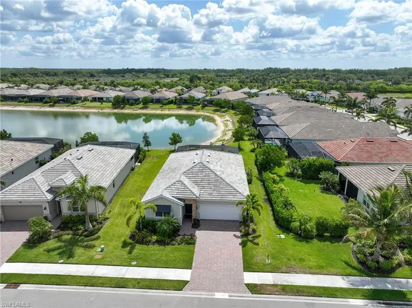 an aerial view of a house with a garden and lake view