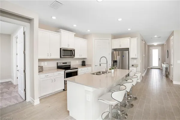 a large white kitchen with stainless steel appliances