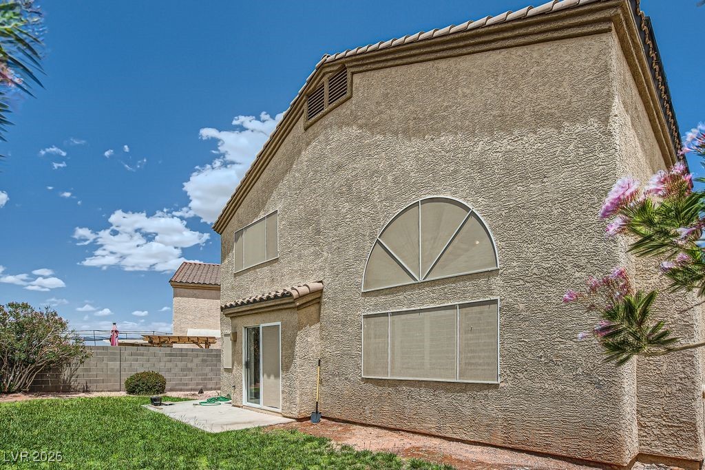 591 Fox Chase Street Henderson, NV 89015 - Photo 14 of 22 Back of house featuring stucco siding and a tiled roof