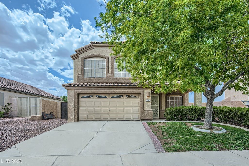 591 Fox Chase Street Henderson, NV 89015 - Photo 2 of 22 View of front of home featuring a tile roof, stucco siding, driveway, and an attached garage