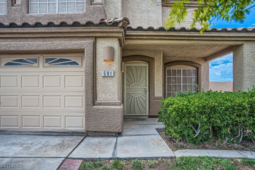 591 Fox Chase Street Henderson, NV 89015 - Photo 3 of 22 Doorway to property with covered porch, a tile roof, and stucco siding