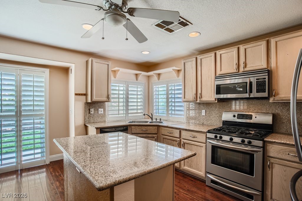 591 Fox Chase Street Henderson, NV 89015 - Photo 6 of 22 Kitchen featuring stainless steel appliances, light brown cabinets, light stone countertops, and recessed lighting