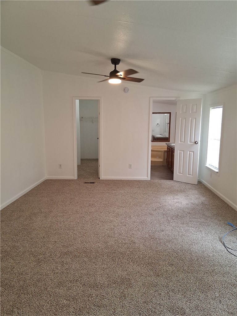910 Sands Road Cave Springs, AR 72718 - Photo 10 of 11 Spacious room with neutral-toned carpet, a ceiling fan with integrated lighting, and multiple entryways