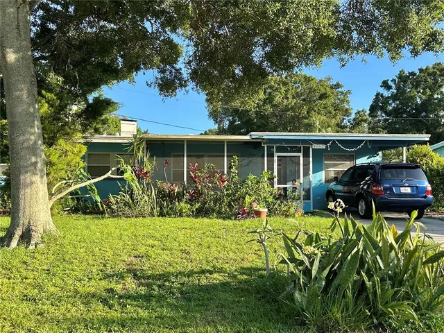 a view of a house with backyard and sitting area