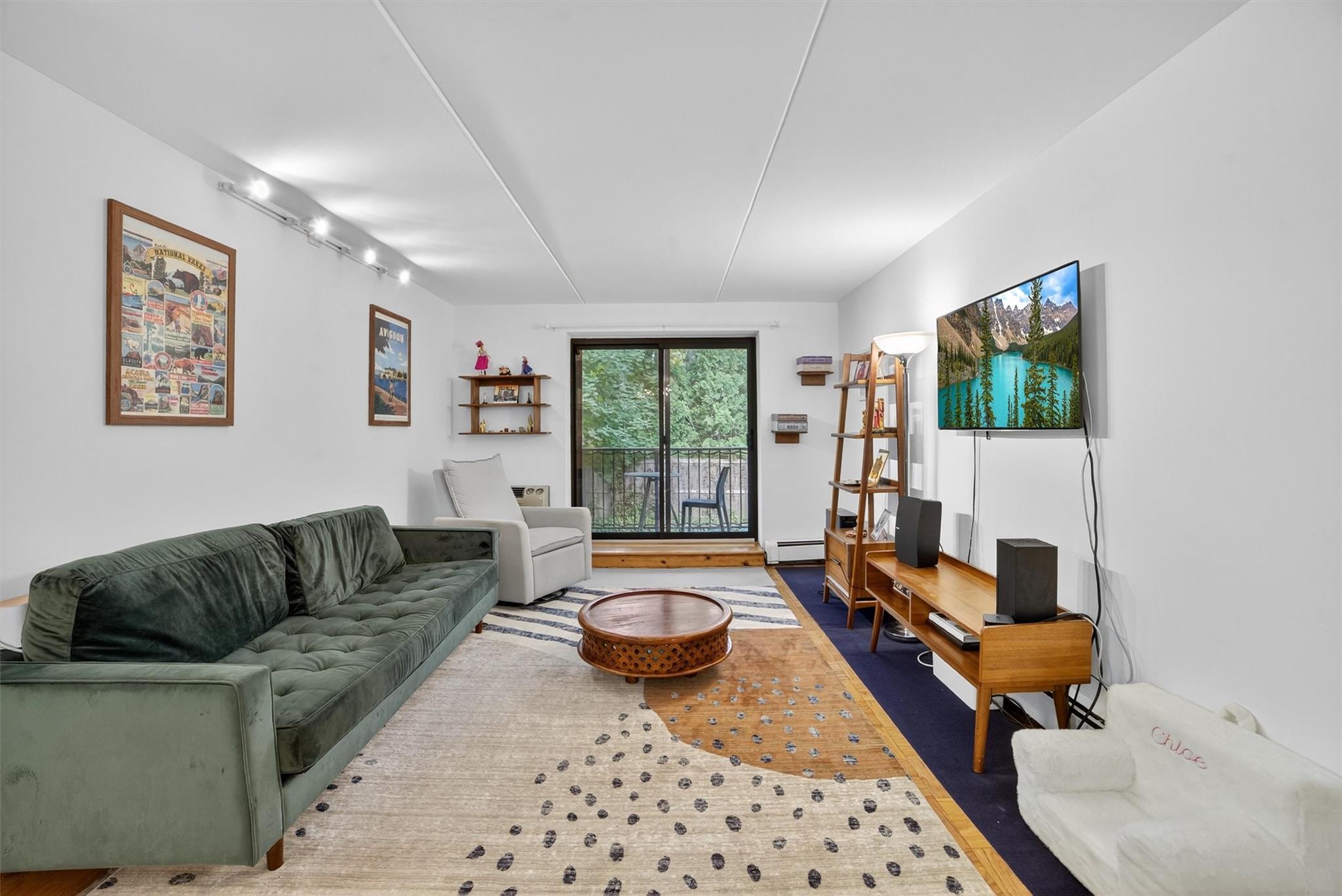 108 Sagamore Road, Unit 5F Tuckahoe, NY 10707 - Photo 19 of 33 Living area with rail lighting, a baseboard heating unit, and wood finished floors
