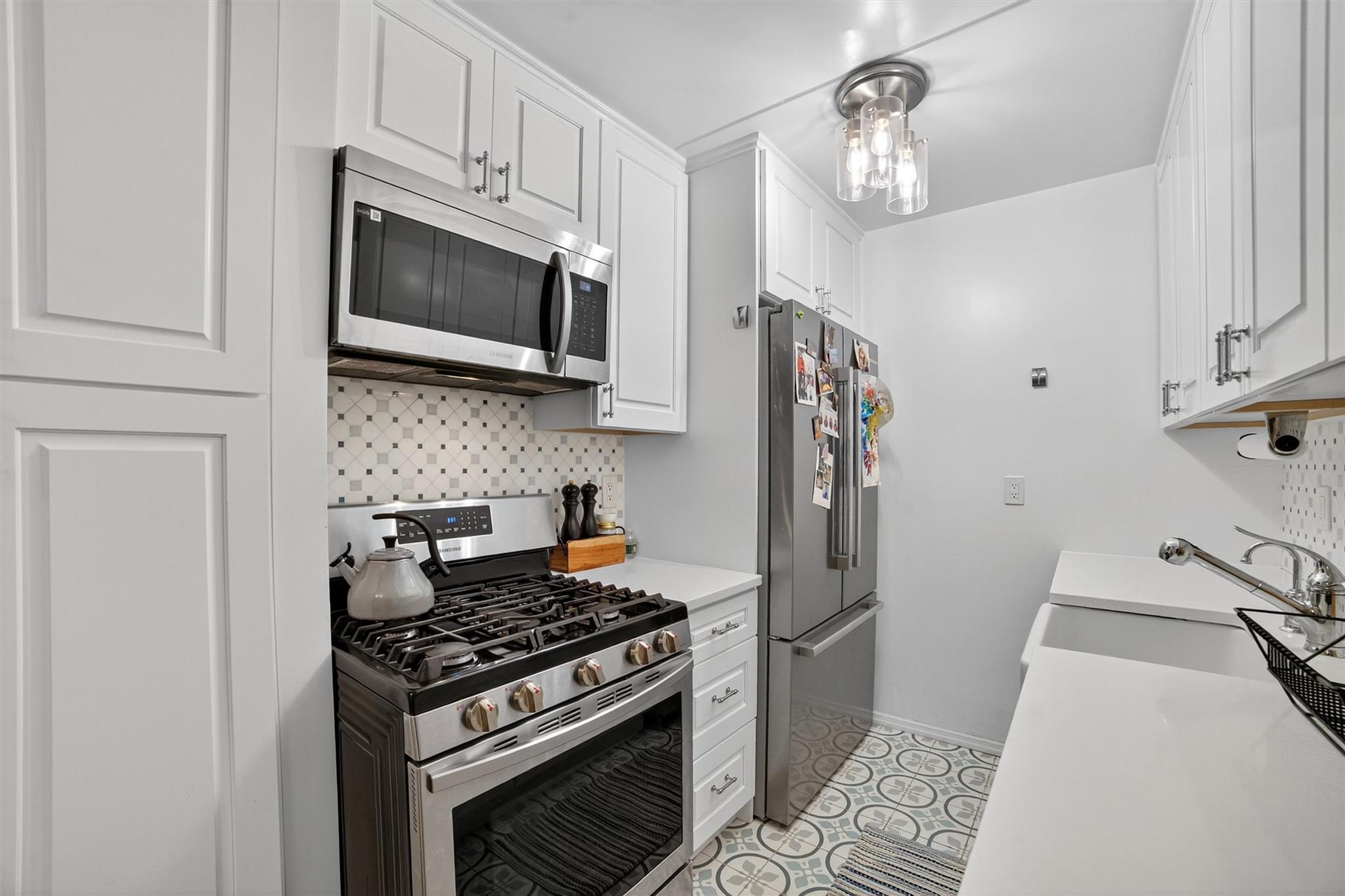 108 Sagamore Road, Unit 5F Tuckahoe, NY 10707 - Photo 21 of 33 Kitchen featuring appliances with stainless steel finishes, decorative backsplash, and white cabinetry
