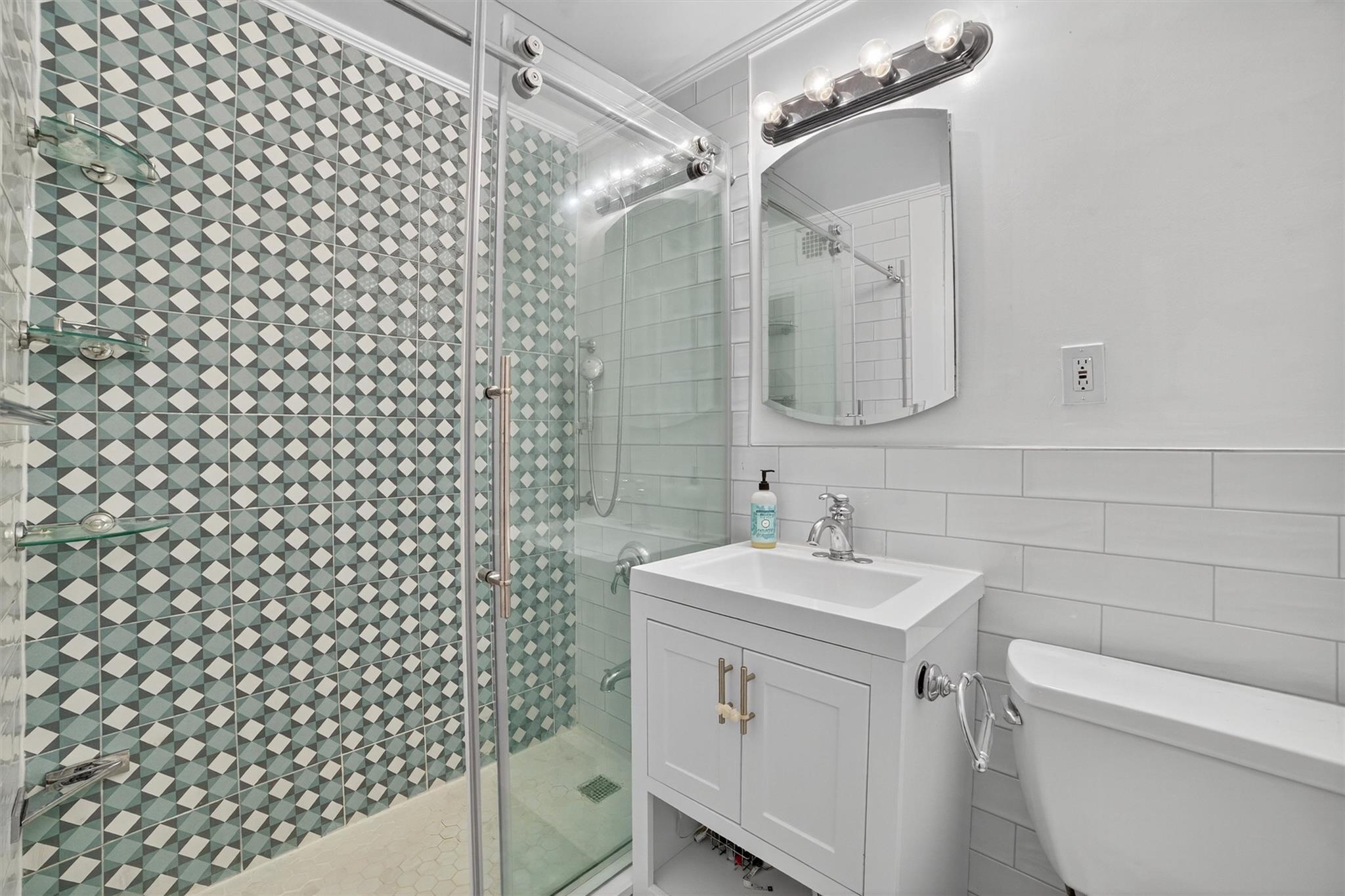 108 Sagamore Road, Unit 5F Tuckahoe, NY 10707 - Photo 28 of 33 Full bath featuring vanity, tile walls, a stall shower, and ornamental molding