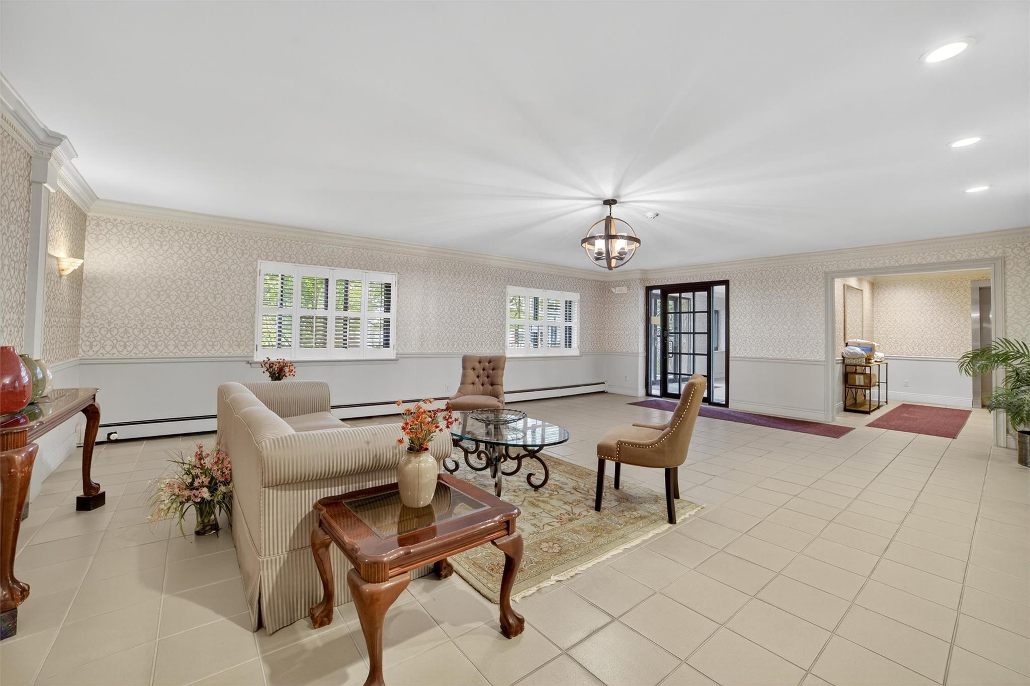 108 Sagamore Road, Unit 5F Tuckahoe, NY 10707 - Photo 6 of 33 Living room with wallpapered walls, ornamental molding, a wainscoted wall, a baseboard radiator, and tile patterned flooring