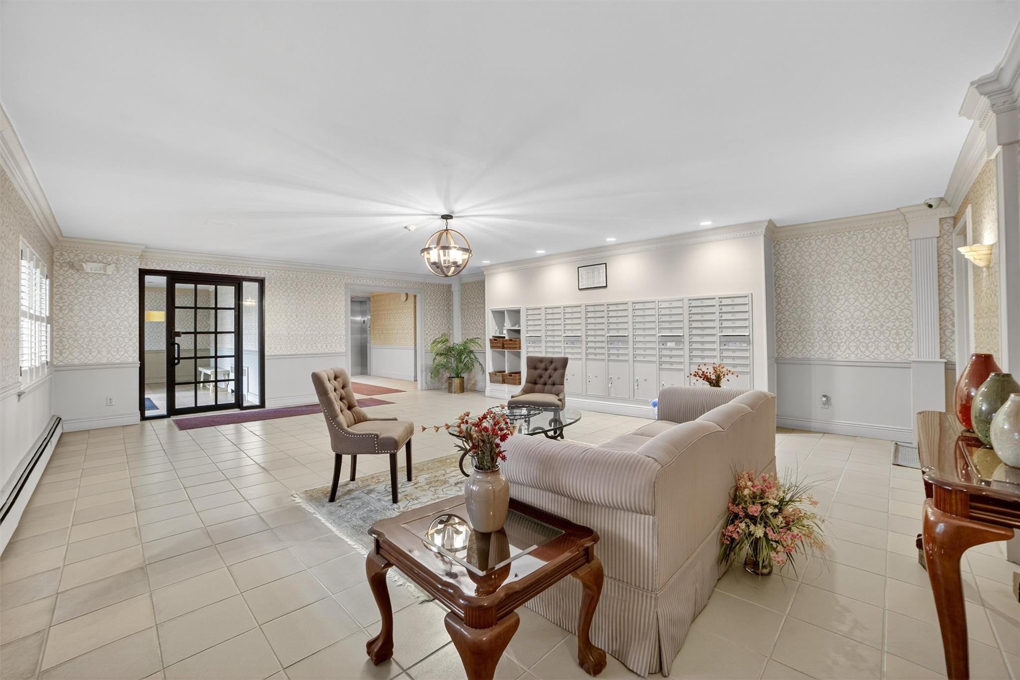 108 Sagamore Road, Unit 5F Tuckahoe, NY 10707 - Photo 7 of 33 Living area featuring wallpapered walls, ornamental molding, a wainscoted wall, tile patterned floors, and a chandelier