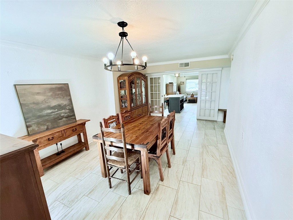 6027 Bluebell Circle Austin, TX 78741 - Photo 6 of 26 a dining room with furniture a chandelier and wooden floor