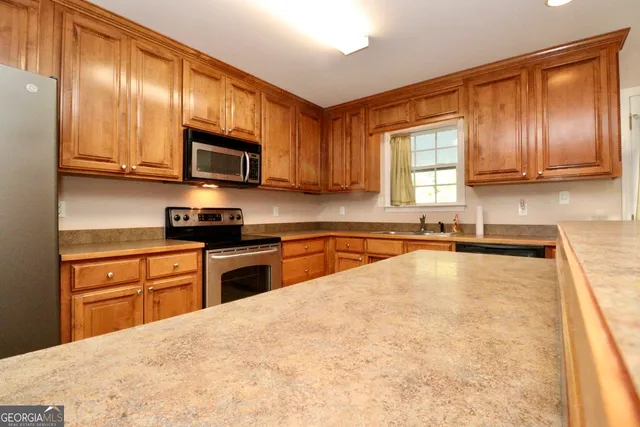 a kitchen with stainless steel appliances granite countertop a stove a sink and a microwave