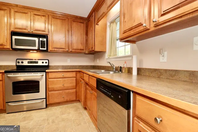 a kitchen with stainless steel appliances granite countertop a sink a stove and microwave