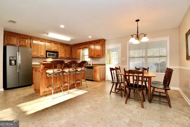 a dining room with furniture a chandelier and window