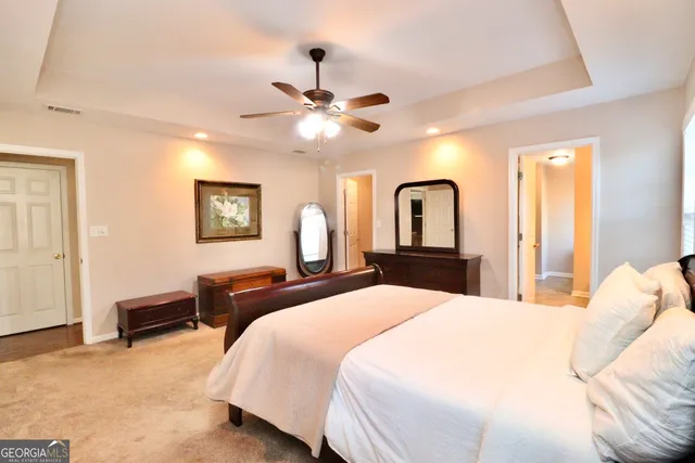 a bedroom with a large bed and a chandelier