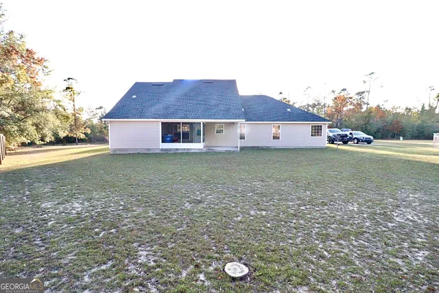 a view of a house with a yard and a large tree