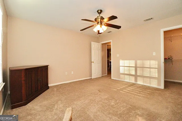 an empty room with windows and fan