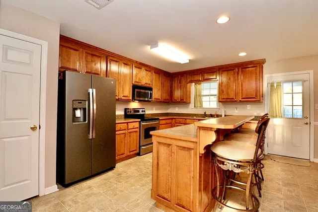 a kitchen with stainless steel appliances granite countertop a refrigerator stove microwave and sink