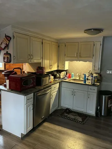 a kitchen with granite countertop a sink and a stove top oven