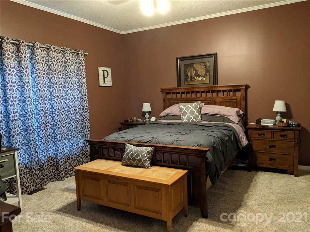 162 Robinson Creek Road Bostic, NC 28018 - Photo 16 of 35 a bedroom with a bed and a wall painting