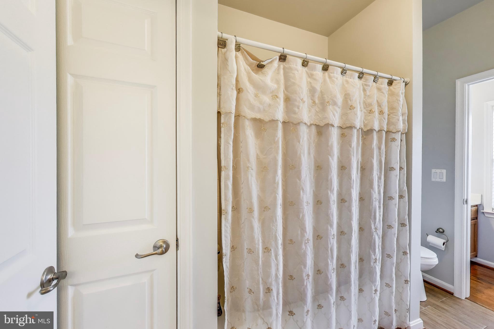 16180 Radburn Street Woodbridge, VA 22191 - Photo 35 of 54 a view of a bathroom with wooden floor and shower curtain