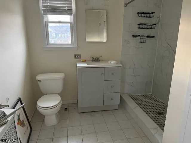 a bathroom with a toilet a sink a window and mirror