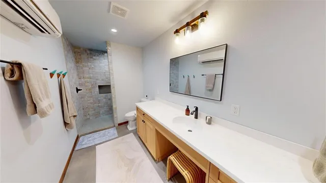 a bathroom with a sink a toilet and shower