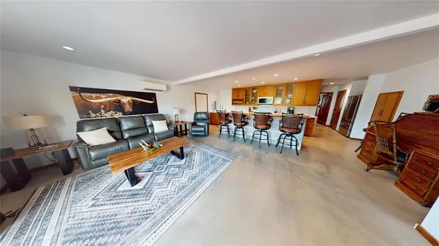 a living room with furniture a rug and a dining table