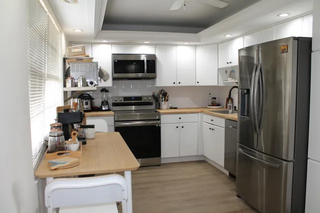 a kitchen with a sink stainless steel appliances and white cabinets