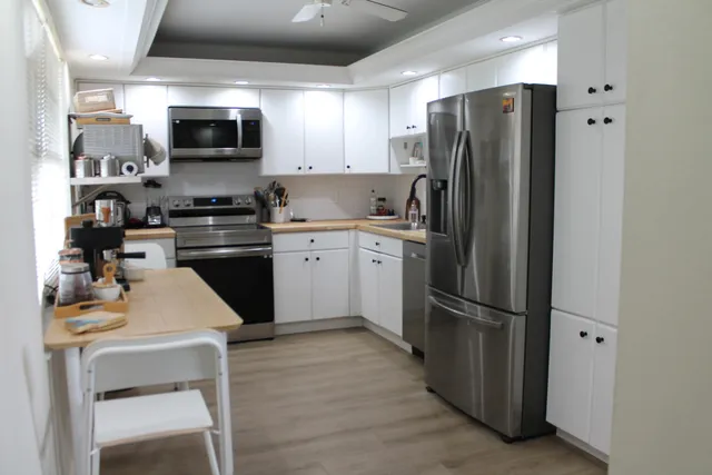 a kitchen with stainless steel appliances granite countertop a refrigerator stove and microwave