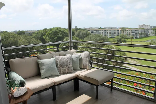 a balcony with wooden floor table and chairs