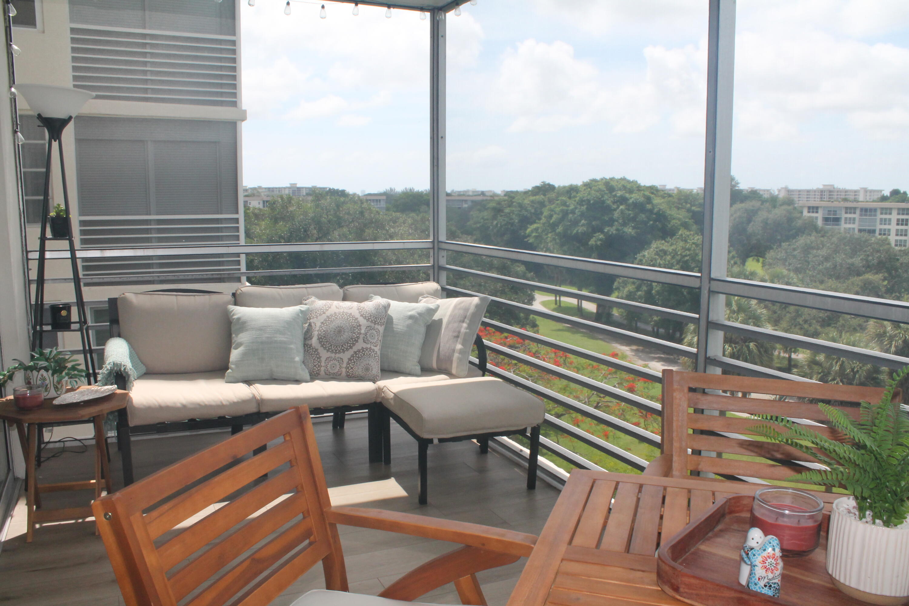 3520 Oaks Way, Unit 607 Pompano Beach, FL 33069 - Photo 33 of 46 a balcony with wooden floor table and chairs