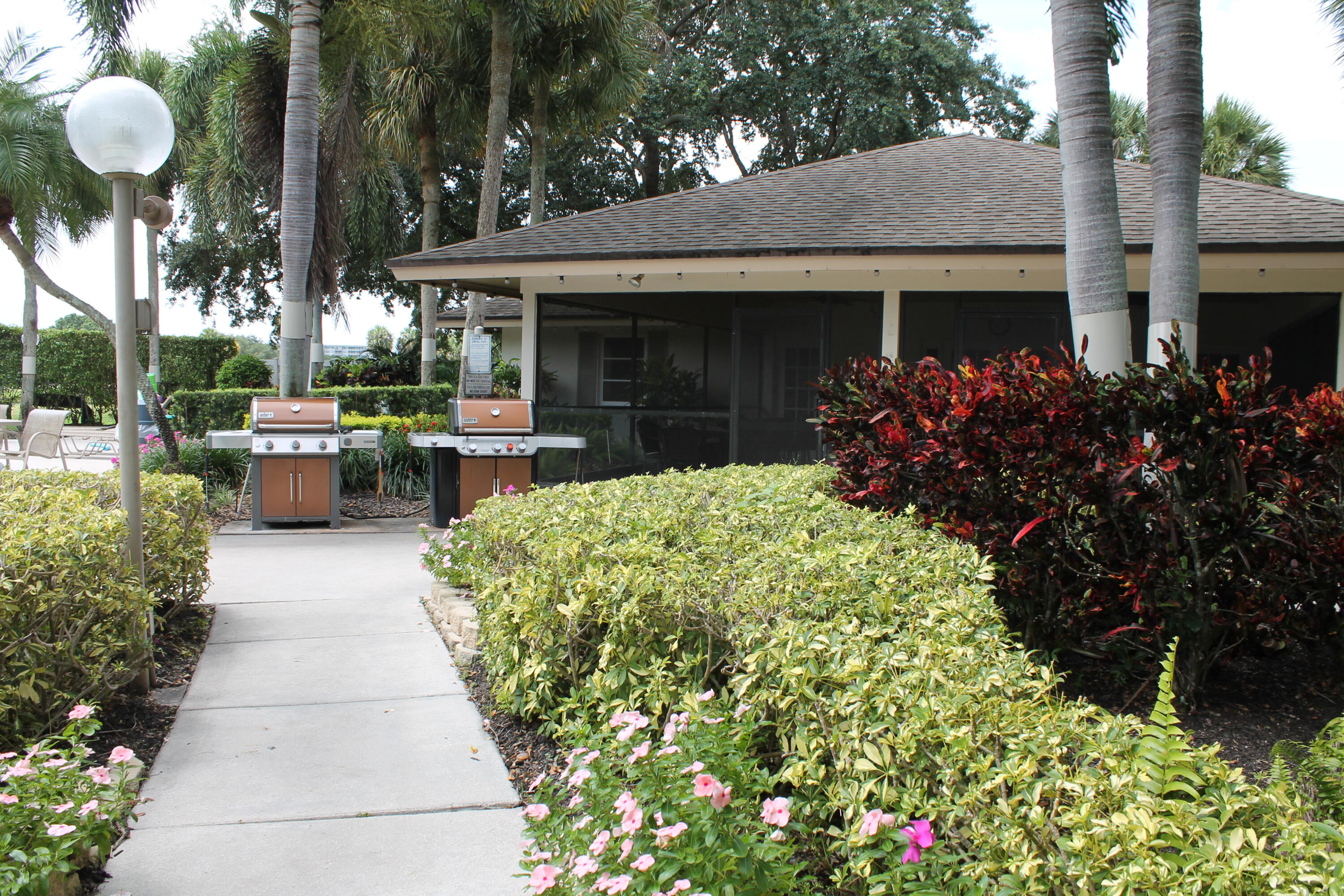 3520 Oaks Way, Unit 607 Pompano Beach, FL 33069 - Photo 38 of 46 a view of a house with a garden and potted plants