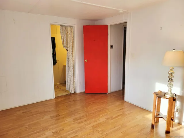 a view of an empty room with closet and a window