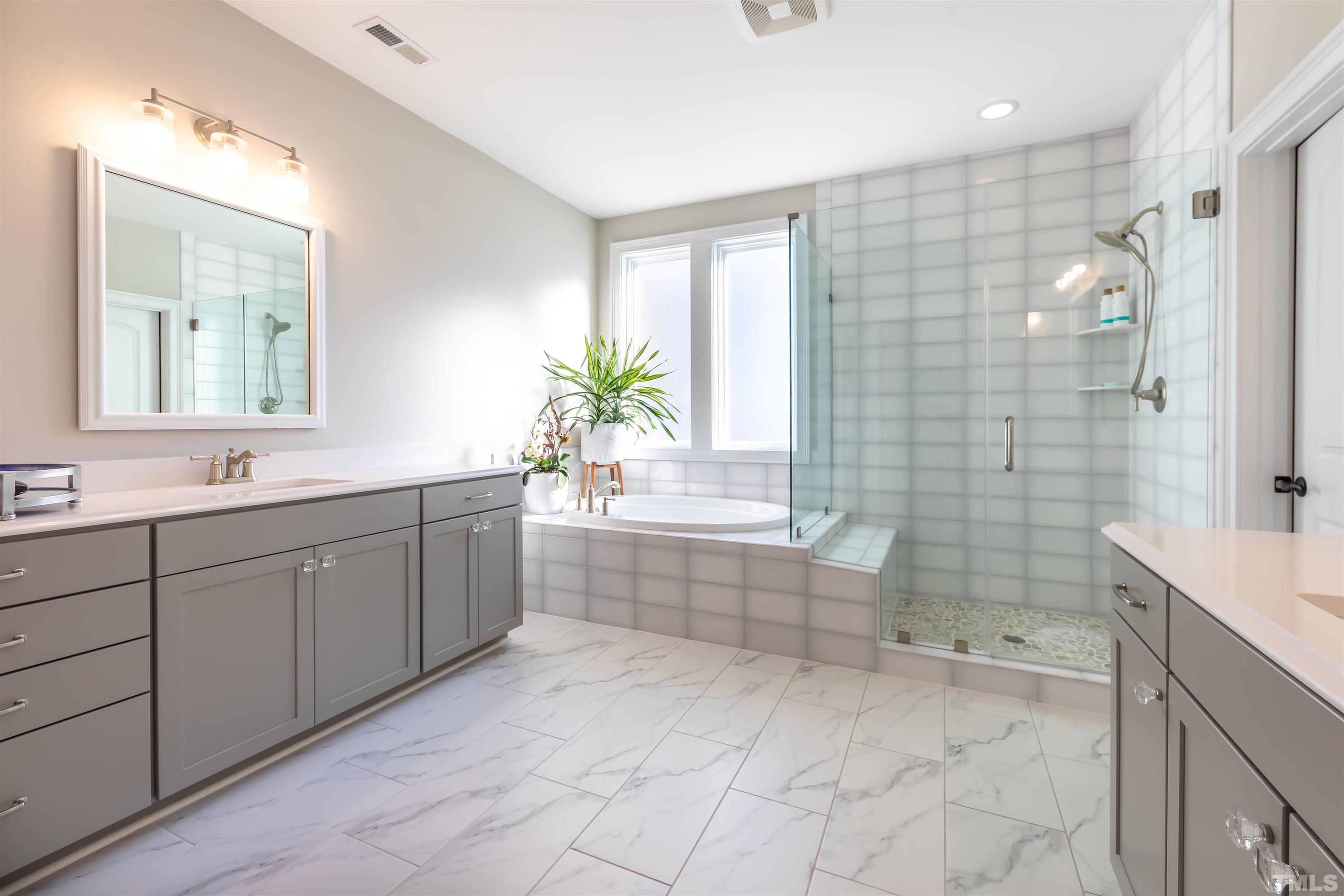 456 Adkins Ridge Road Rolesville, NC 27571 - Photo 15 of 38 a spacious bathroom with a granite countertop sink a toilet a mirror and shower