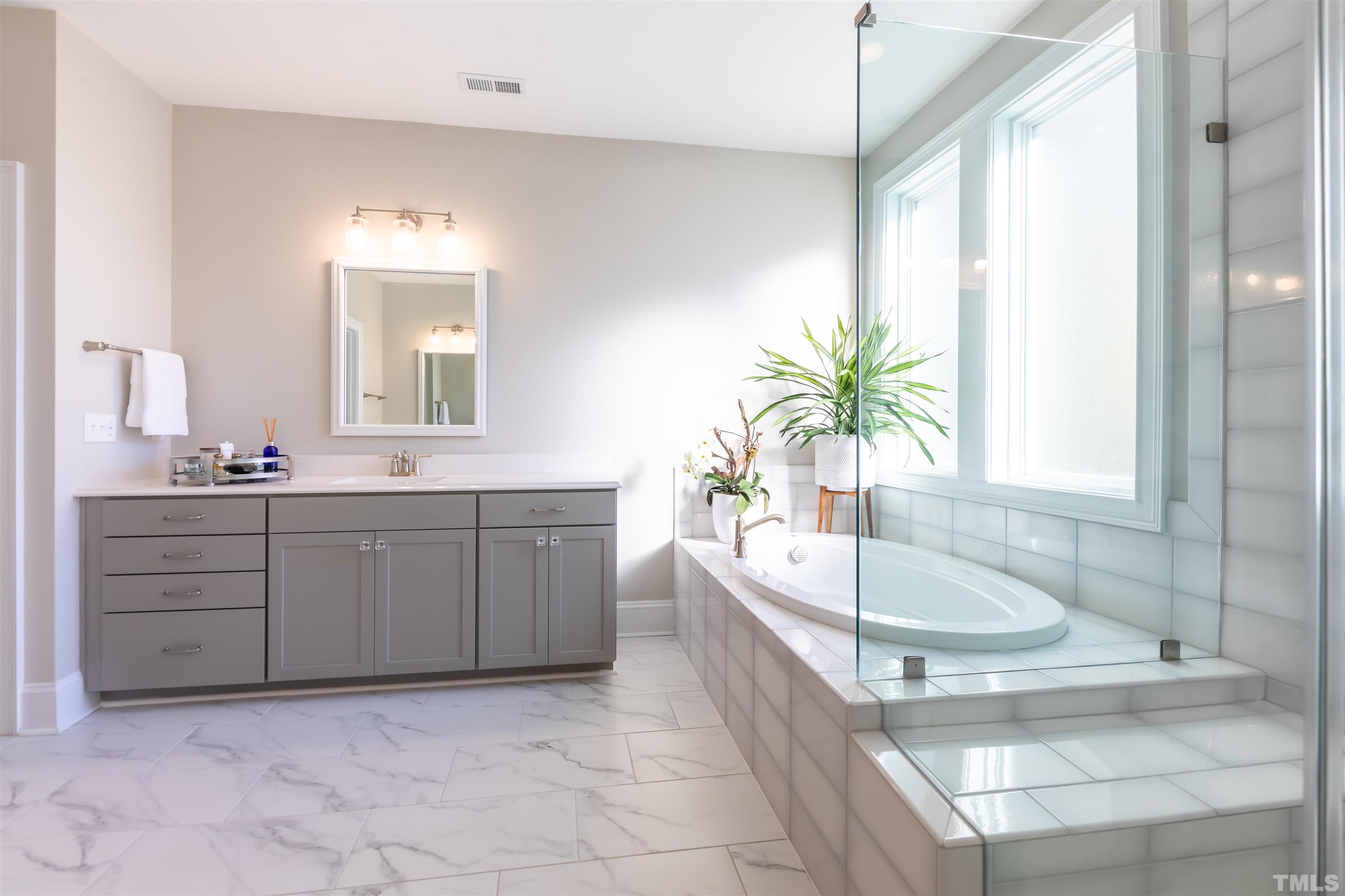 456 Adkins Ridge Road Rolesville, NC 27571 - Photo 16 of 38 a spacious bathroom with a tub sink and mirror