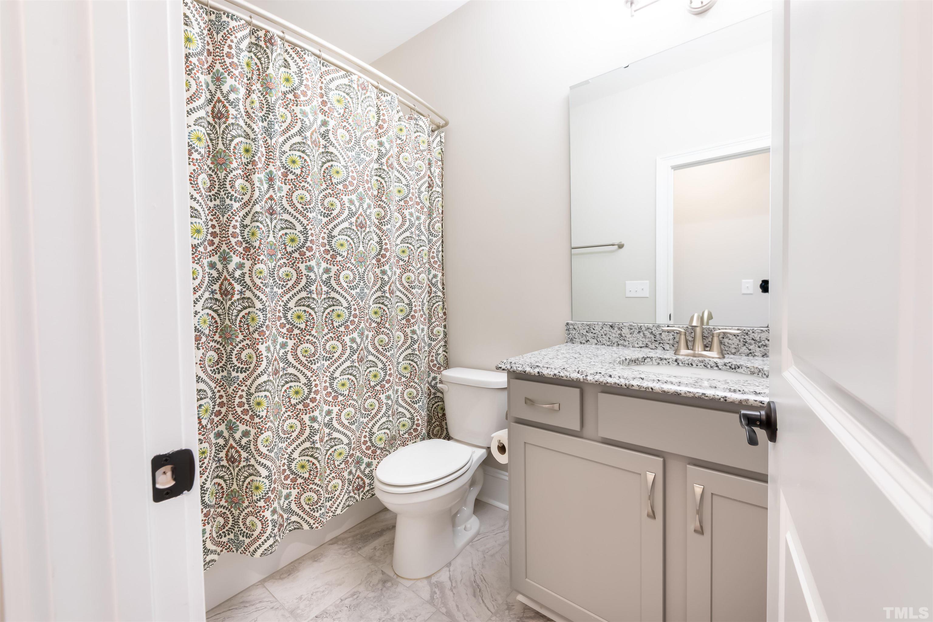456 Adkins Ridge Road Rolesville, NC 27571 - Photo 23 of 38 a bathroom with a granite countertop sink toilet and shower