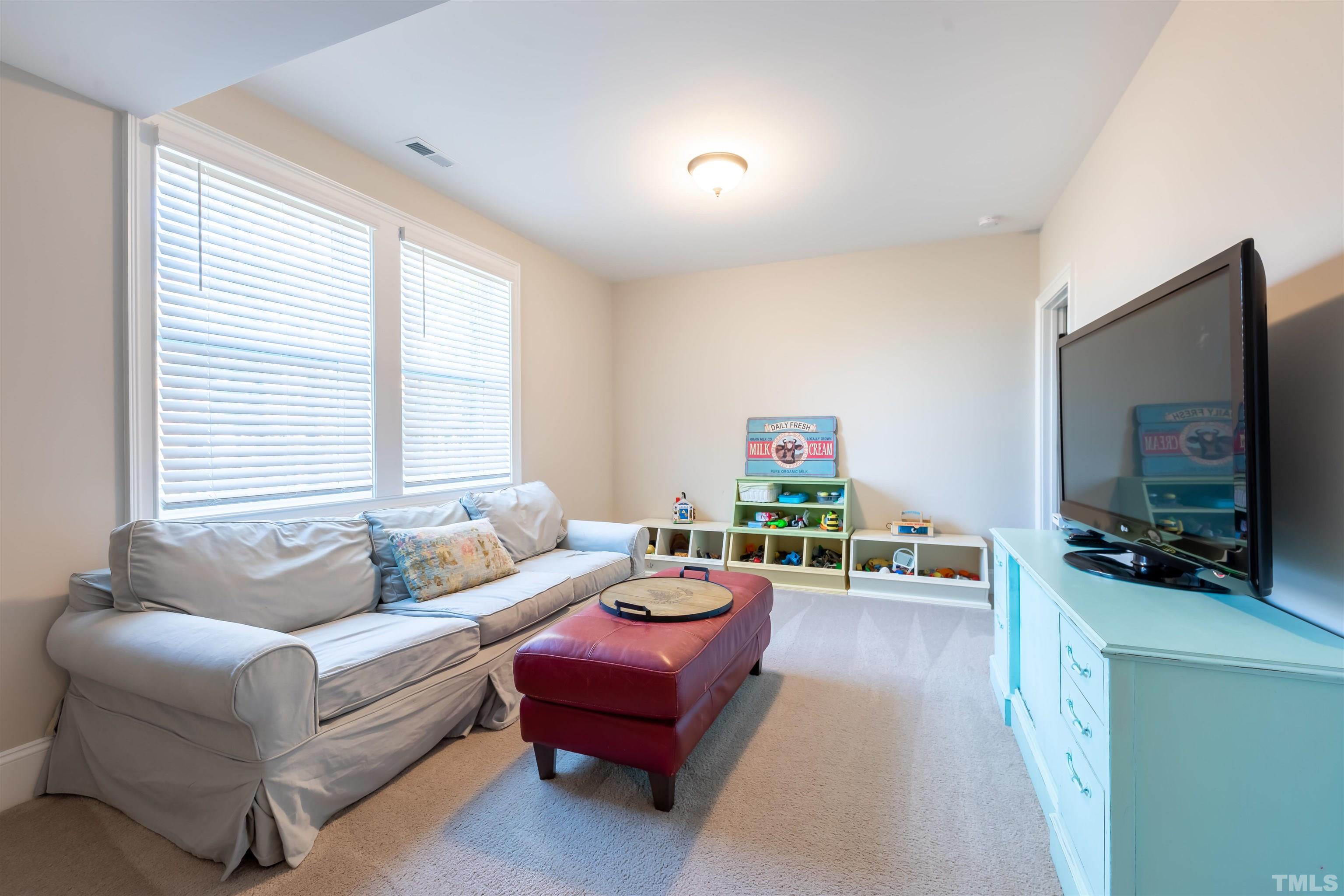 456 Adkins Ridge Road Rolesville, NC 27571 - Photo 30 of 38 a living room with furniture and a flat screen tv
