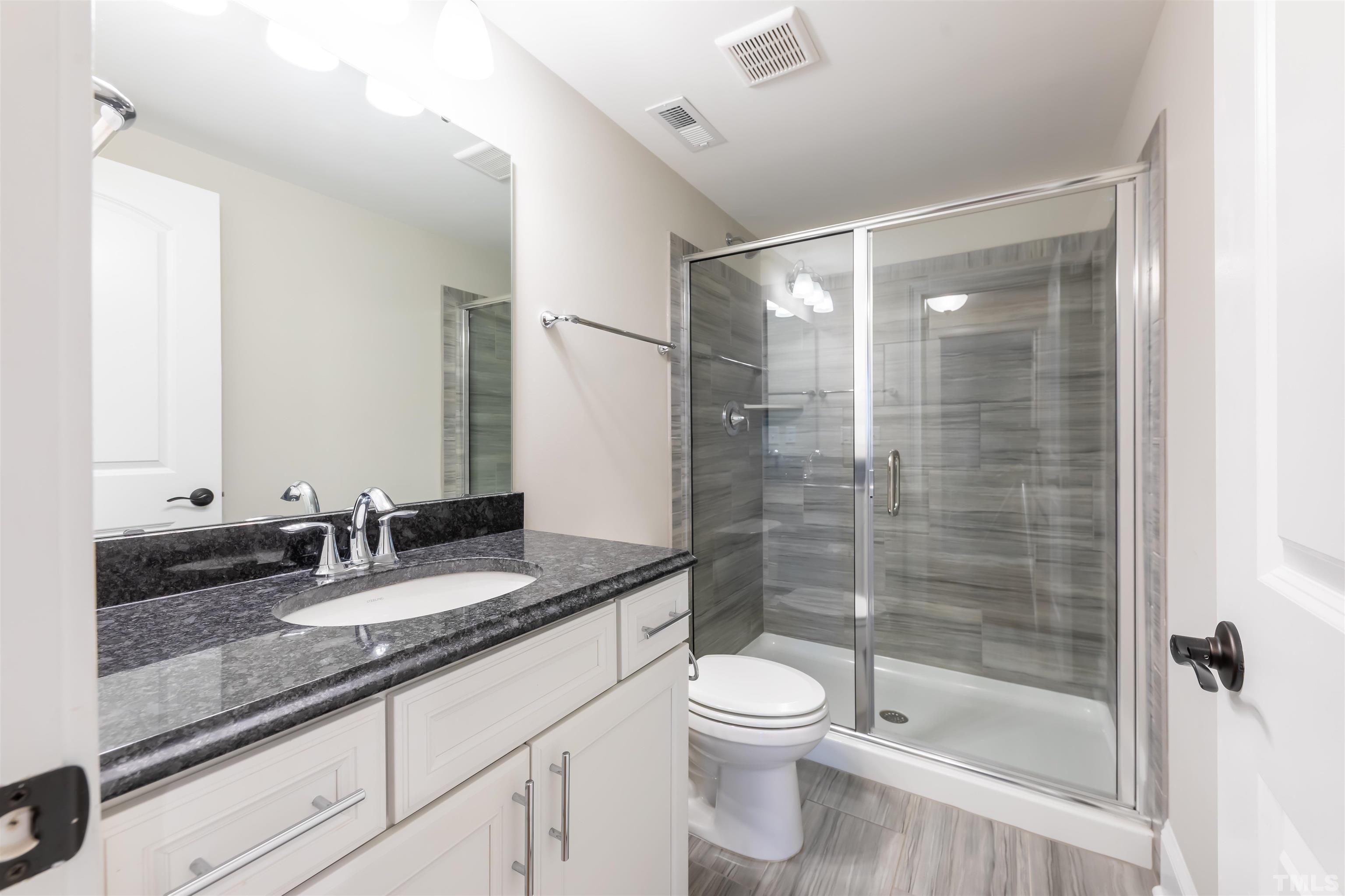 456 Adkins Ridge Road Rolesville, NC 27571 - Photo 31 of 38 a bathroom with a granite countertop sink toilet and shower